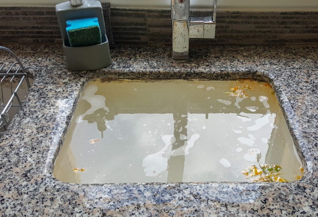 Overflowing kitchen sink, clogged drain. Plumbing problems.